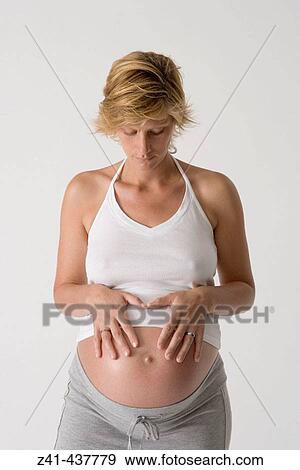 Pregnant woman looking at her belly View Large Photo Image Stock Photo - Pregnant woman looking at her belly. Fotosearch
