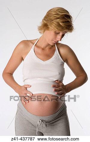 Pregnant woman looking at her belly View Large Photo Image Stock Photo - Pregnant woman looking at her belly. Fotosearch