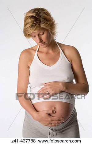 Pregnant woman looking at her belly View Large Photo Image Stock Photo - Pregnant woman looking at her belly. Fotosearch