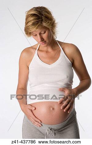 Pregnant woman looking at her belly View Large Photo Image Stock Photograph - Pregnant woman looking at her belly. Fotosearch