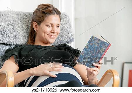Pregnant woman lying in lounge chair and reading a diary View Large Photo Image Stock Photography - Pregnant woman lying in lounge chair and reading a diary. Fotosearch