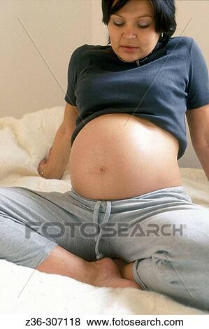 Stock Photo - Pregnant woman on bed. Fotosearch