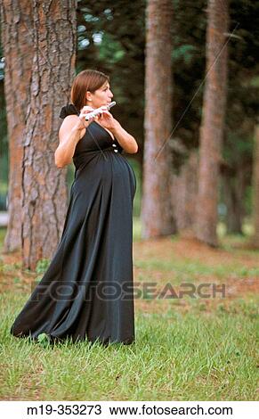 Stock Image - pregnant woman playing flute. Fotosearch