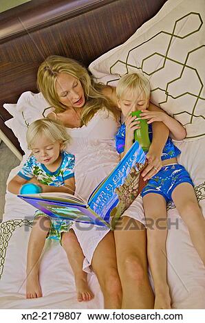 Pregnant woman reading to her two young boys. View Large Photo Image Stock Photo - Pregnant woman reading to her two young boys.. Fotosearch