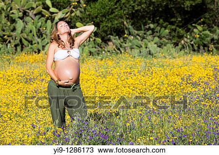 Pregnant woman relaxing in field View Large Photo Image Stock Image - Pregnant woman relaxing in field. Fotosearch