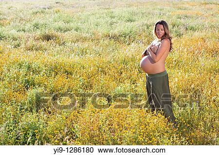 Pregnant woman relaxing in field View Large Photo Image Stock Image - Pregnant woman relaxing in field. Fotosearch