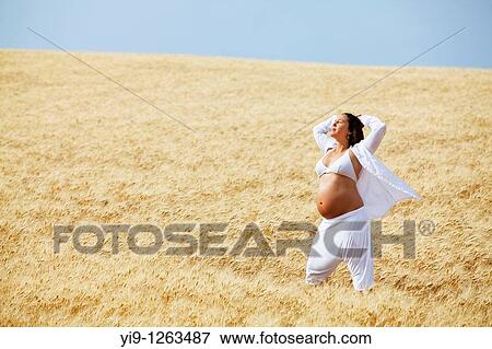 Pregnant woman relaxing in field View Large Photo Image Stock Photo - Pregnant woman relaxing in field. Fotosearch