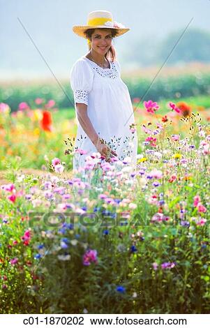 Pregnant woman standing in flower garden View Large Photo Image Stock Image - Pregnant woman standing in flower garden. Fotosearch