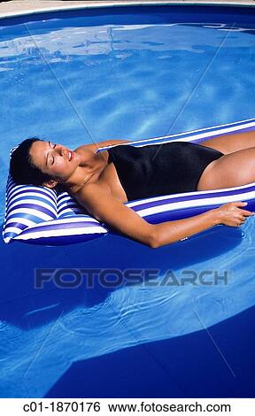 Pregnant woman sunbathing on mattress in swimming pool View Large Photo Image Stock Photograph - Pregnant woman sunbathing on mattress in swimming pool. Fotosearch