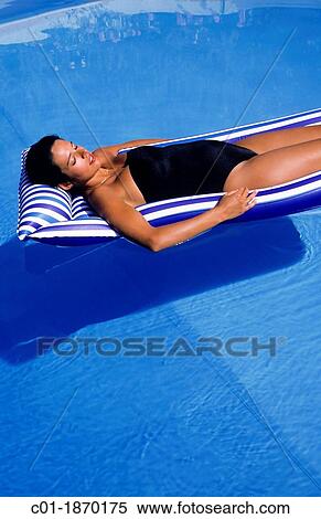 Pregnant woman sunbathing on mattress in swimming pool View Large Photo Image Stock Photography - Pregnant woman sunbathing on mattress in swimming pool. Fotosearch