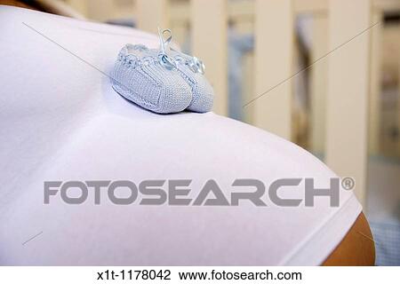 Pregnant woman with baby booties. View Large Photo Image Stock Image - Pregnant woman with baby booties.. Fotosearch