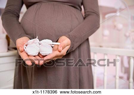 Pregnant woman with baby booties. View Large Photo Image Stock Photograph - Pregnant woman with baby booties.. Fotosearch