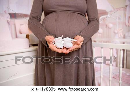 Pregnant woman with baby booties. View Large Photo Image Stock Photography - Pregnant woman with baby booties.. Fotosearch