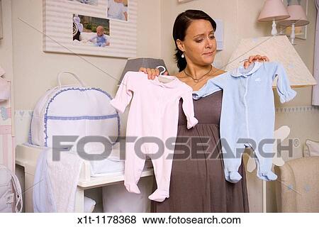 Pregnant woman with baby clothes. View Large Photo Image Stock Photo - Pregnant woman with baby clothes.. Fotosearch