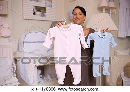 Pregnant woman with baby clothes. View Large Photo Image Stock Photograph - Pregnant woman with baby clothes.. Fotosearch