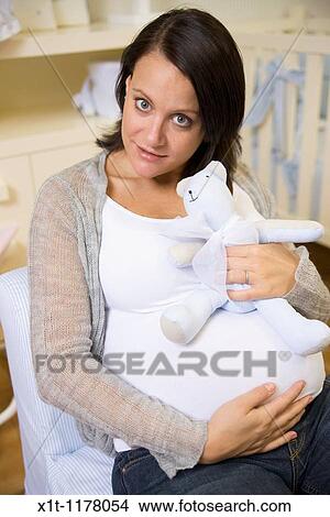 Pregnant women in the baby's room. View Large Photo Image Picture - Pregnant women in the baby's room.. Fotosearch