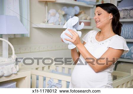 Stock Image - Pregnant women in the baby's room.. Fotosearch