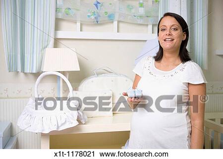 Stock Image - Pregnant women in the baby's room.. Fotosearch
