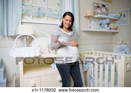 Stock Image - Pregnant women in the baby's room.. Fotosearch