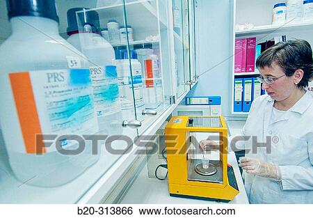 Stock Photograph - Preparing medicine at chemist of hospital with a precision scale. Fotosearch