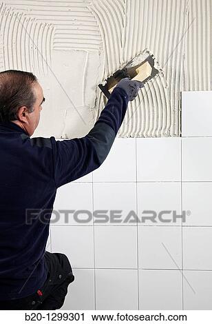 Preparing wall with glue mortar before tiling using a serrated plastering trowel, new homes under construction, construction site View Large Photo Image Stock Image - Preparing wall with glue mortar before tiling using a serrated plastering trowel, new homes under construction, construction site. Fotosearch
