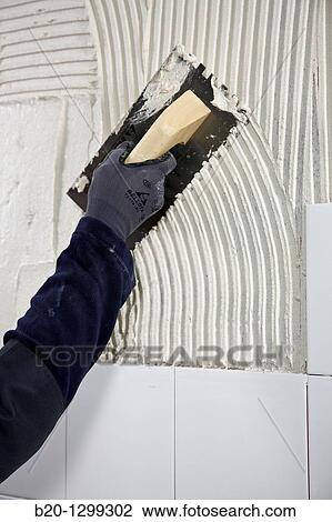 Preparing wall with glue mortar before tiling using a serrated plastering trowel, new homes under construction, construction site View Large Photo Image Stock Image - Preparing wall with glue mortar before tiling using a serrated plastering trowel, new homes under construction, construction site. Fotosearch