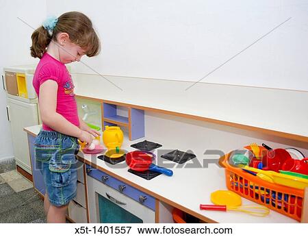 Preschool girl of 5 plays with a toy kitchen View Large Photo Image Stock Photo - Preschool girl of 5 plays with a toy kitchen. Fotosearch