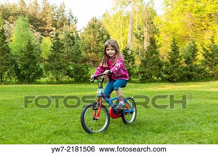 Stock Photograph - Preschool girl riding her bicycle.. Fotosearch