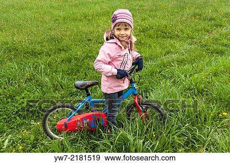 Preschool girl with her bicycle on meadow. View Large Photo Image Stock Photo - Preschool girl with her bicycle on meadow.. Fotosearch
