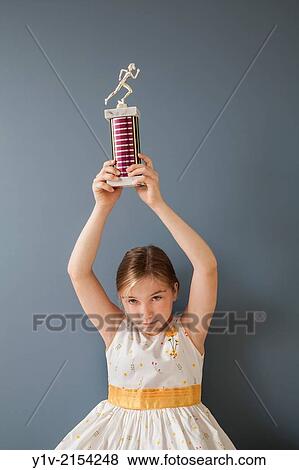 Stock Photo - Preteen blond girl holding a trophy.. Fotosearch