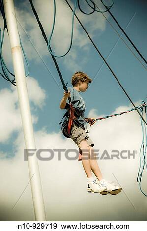 Preteen boy on a rubber band ride at a fair View Large Photo Image Stock Photo - Preteen boy on a rubber band ride at a fair. Fotosearch