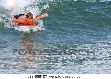 Preteen boy riding the wave on a boogie board. Sandbridge Beach, Virginia Beach, Virginia, USA View Large Photo Image Stock Photo - Preteen boy riding the wave on a boogie board. Sandbridge Beach, Virginia Beach, Virginia, USA. Fotosearch