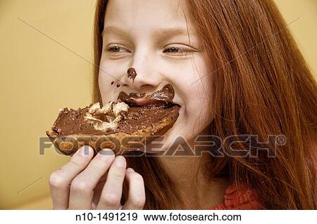 Stock Photo - Preteen girl eating a bagel. Fotosearch