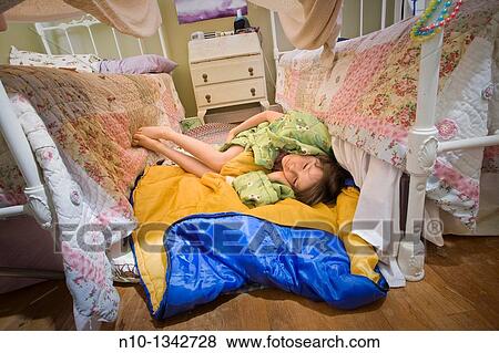 Preteen girl lying between her two beds View Large Photo Image Stock Photo - Preteen girl lying between her two beds. Fotosearch