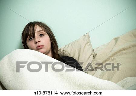 Preteen girl lying on her bed. View Large Photo Image Picture - Preteen girl lying on her bed.. Fotosearch
