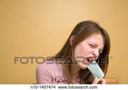 Picture - Preteen girl pulling tape off her mouth. Fotosearch