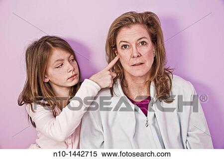 Preteen girl sticking her finger in her mother's ear View Large Photo Image Stock Photography - Preteen girl sticking her finger in her mother's ear. Fotosearch