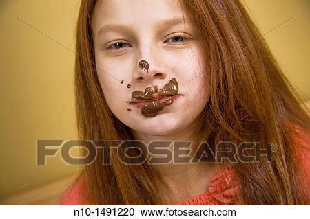 Stock Image - Preteen girl with chocolate on her face. Fotosearch