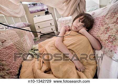 Preteen girl, with headphones, under a homemade bedroom tent View Large Photo Image Stock Photo - Preteen girl, with headphones, under a homemade bedroom tent. Fotosearch