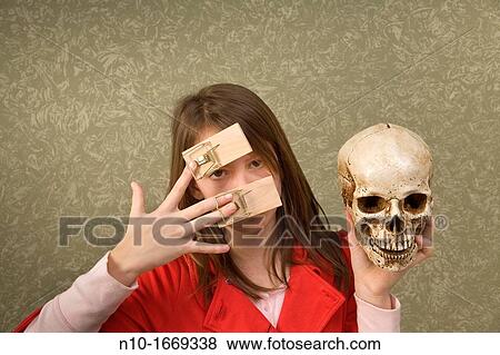 Preteen girl, with mousetraps on her fingers, holding a skull View Large Photo Image Stock Photo - Preteen girl, with mousetraps on her fingers, holding a skull. Fotosearch