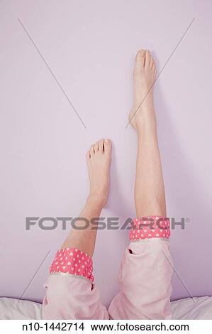 Picture - Preteen girl's legs and feet resting on a wall. Fotosearch
