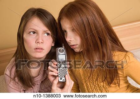 Preteen girls using a portable phone View Large Photo Image Stock Image - Preteen girls using a portable phone. Fotosearch