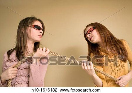 Preteen girls, wearing sunglasses, pulling on a rope View Large Photo Image Stock Image - Preteen girls, wearing sunglasses, pulling on a rope. Fotosearch