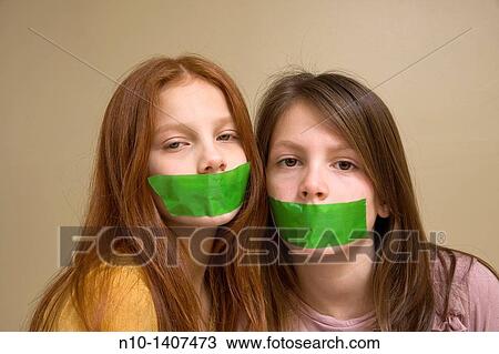 Preteen girls with green tape on their mouths View Large Photo Image Stock Image - Preteen girls with green tape on their mouths. Fotosearch