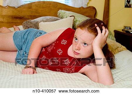 Preteen redhead girl, in Connecticut, USA, reclining on her mother's bed, thinking. View Large Photo Image Stock Photo - Preteen redhead girl, in Connecticut, USA, reclining on her mother's bed, thinking.. Fotosearch
