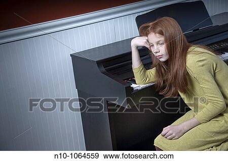 Preteen redhead girl sitting at an electric piano View Large Photo Image Stock Photo - Preteen redhead girl sitting at an electric piano. Fotosearch