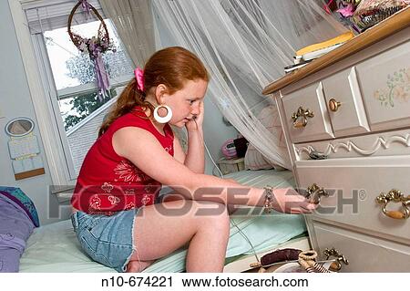 Preteen redhead girl, wearing large earrings, sitting on her bed, talking on the telephone. View Large Photo Image Stock Image - Preteen redhead girl, wearing large earrings, sitting on her bed, talking on the telephone.. Fotosearch