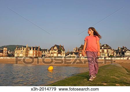 preteen walking on sea wall along the beach, Houlgate, small tourist resort in northwestern France along the English Channel, Pays d'Auge, Calvados department, Lower Normandy region, Northwestern France, Western Europe. View Large Photo Image Stock Photo - preteen walking on sea wall along the beach, Houlgate, small tourist resort in northwestern France along the English Channel, Pays d'Auge, Calvados department, Lower Normandy region, Northwestern France, Western Europe.. Fotosearch