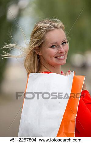 Picture - Pretty blonde woman happy with her shopping bag. Fotosearch