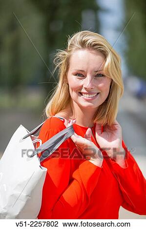 Pretty blonde woman happy with her shopping bag View Large Photo Image Stock Image - Pretty blonde woman happy with her shopping bag. Fotosearch
